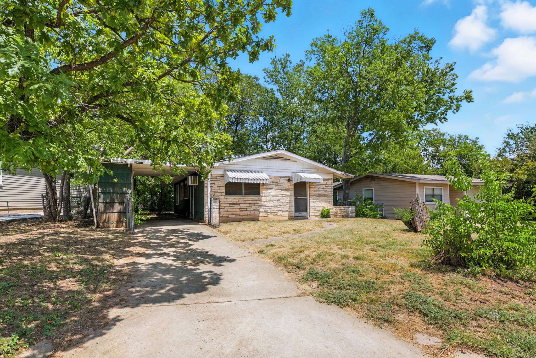 3709 Tower View Court Austin, TX 78723 - Photo 3 of 11 Single story home featuring driveway, a front lawn, stone siding, and an attached carport