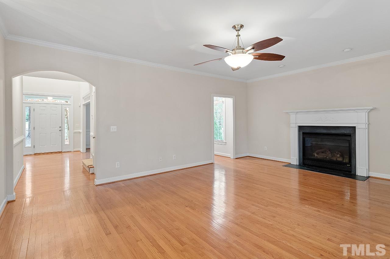 12724 Amoretto Way Raleigh, NC 27613 - Photo 12 of 44 a view of an empty room with wooden floor fireplace and a window