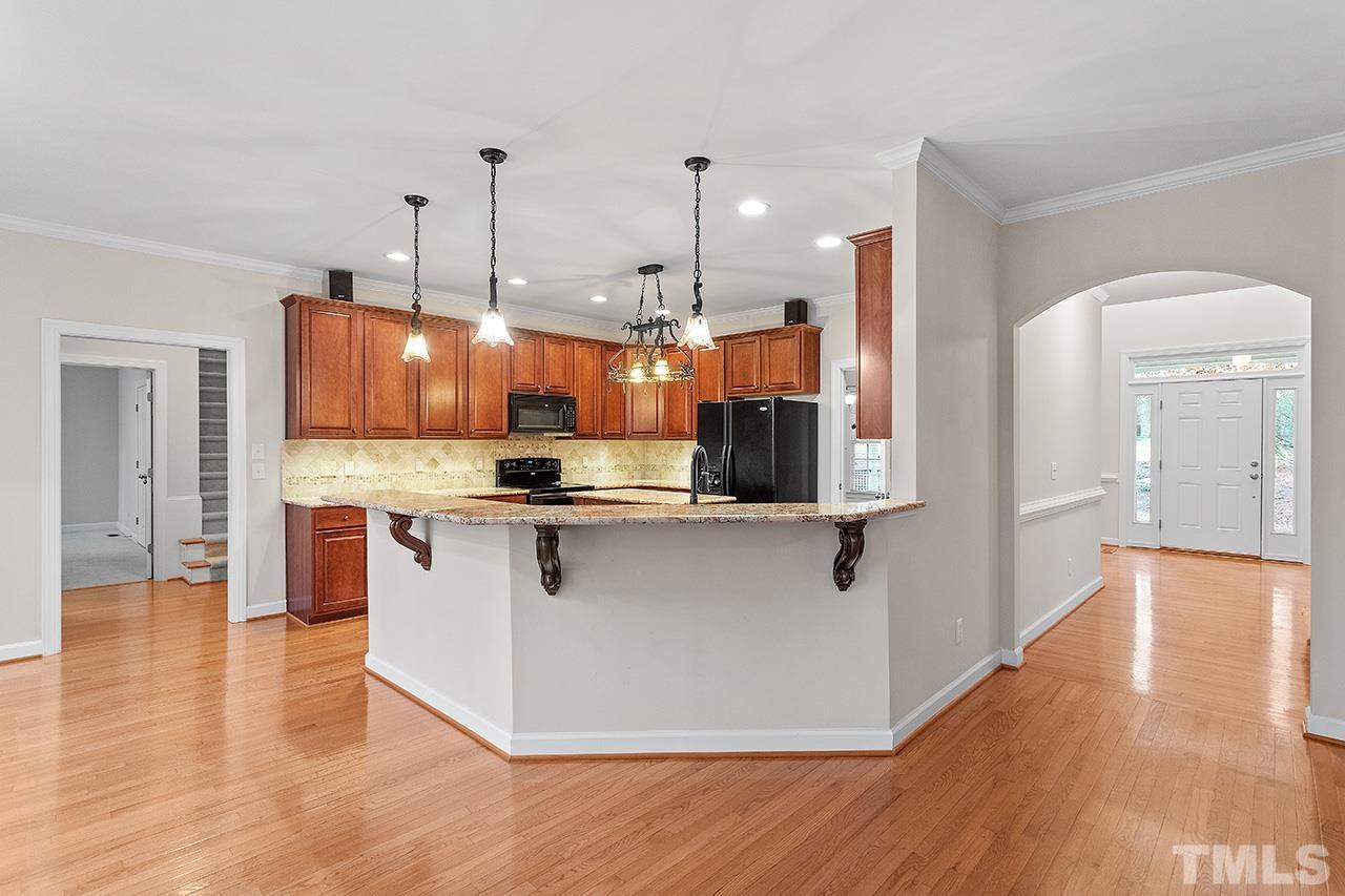 12724 Amoretto Way Raleigh, NC 27613 - Photo 19 of 44 a kitchen with stainless steel appliances kitchen island a sink and a refrigerator