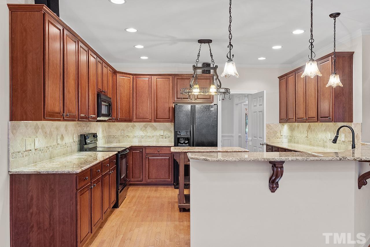 12724 Amoretto Way Raleigh, NC 27613 - Photo 20 of 44 a kitchen with stainless steel appliances granite countertop a sink a stove and a refrigerator