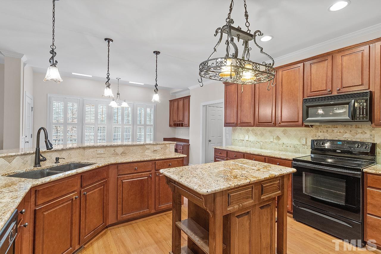 12724 Amoretto Way Raleigh, NC 27613 - Photo 21 of 44 a kitchen with a sink a stove and cabinets
