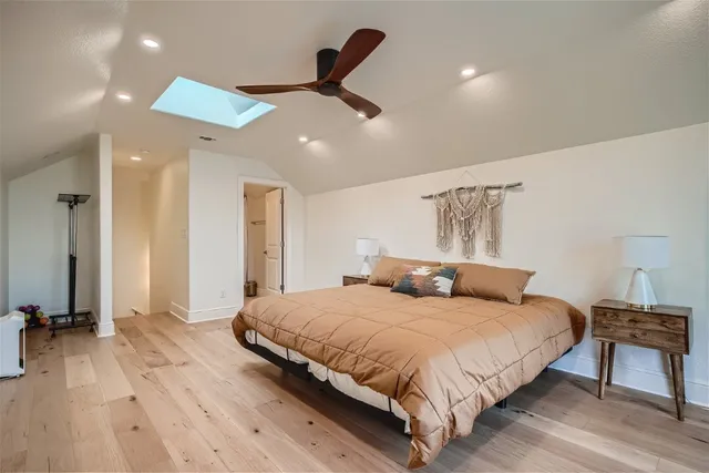 a bedroom with a bed chandelier and a window