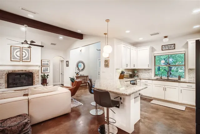 a living room with furniture a fireplace and kitchen view