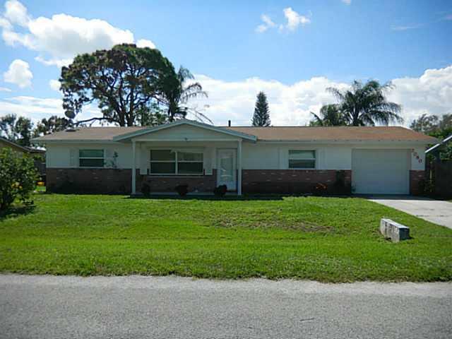 2080 Southeast Madison Street Stuart, FL 34997 - Photo 1 of 25 a front view of a house with a garden