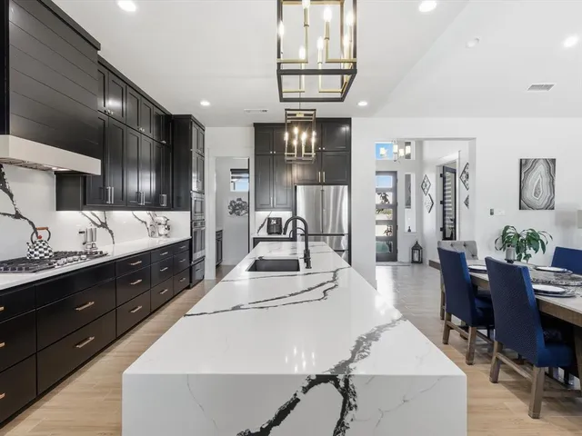 a large kitchen with stainless steel appliances lots of counter space and breakfast area