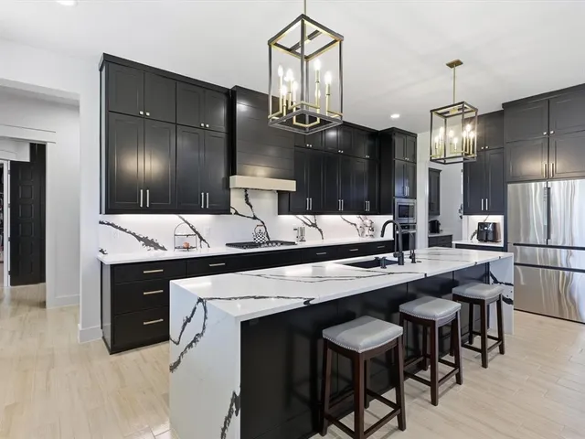 a kitchen with stainless steel appliances a sink stove and refrigerator