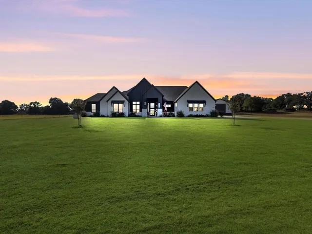 a view of a large pool with lawn chairs and large trees