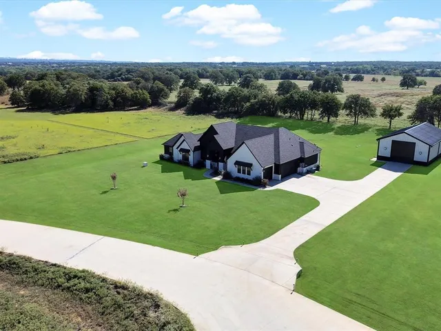 an aerial view of a house with big yard