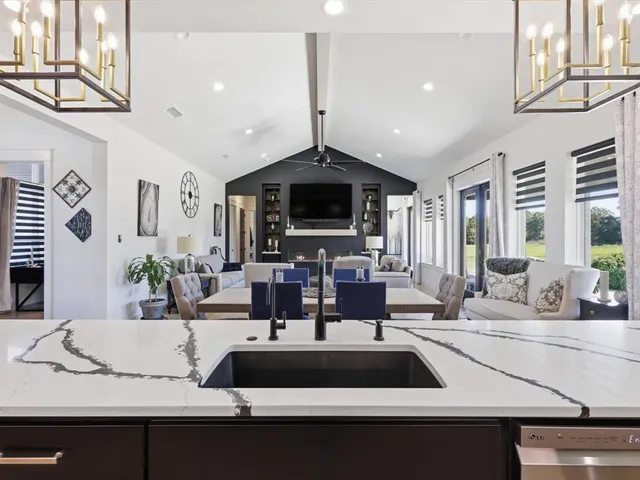 a view of living room with kitchen island furniture and a flat screen tv