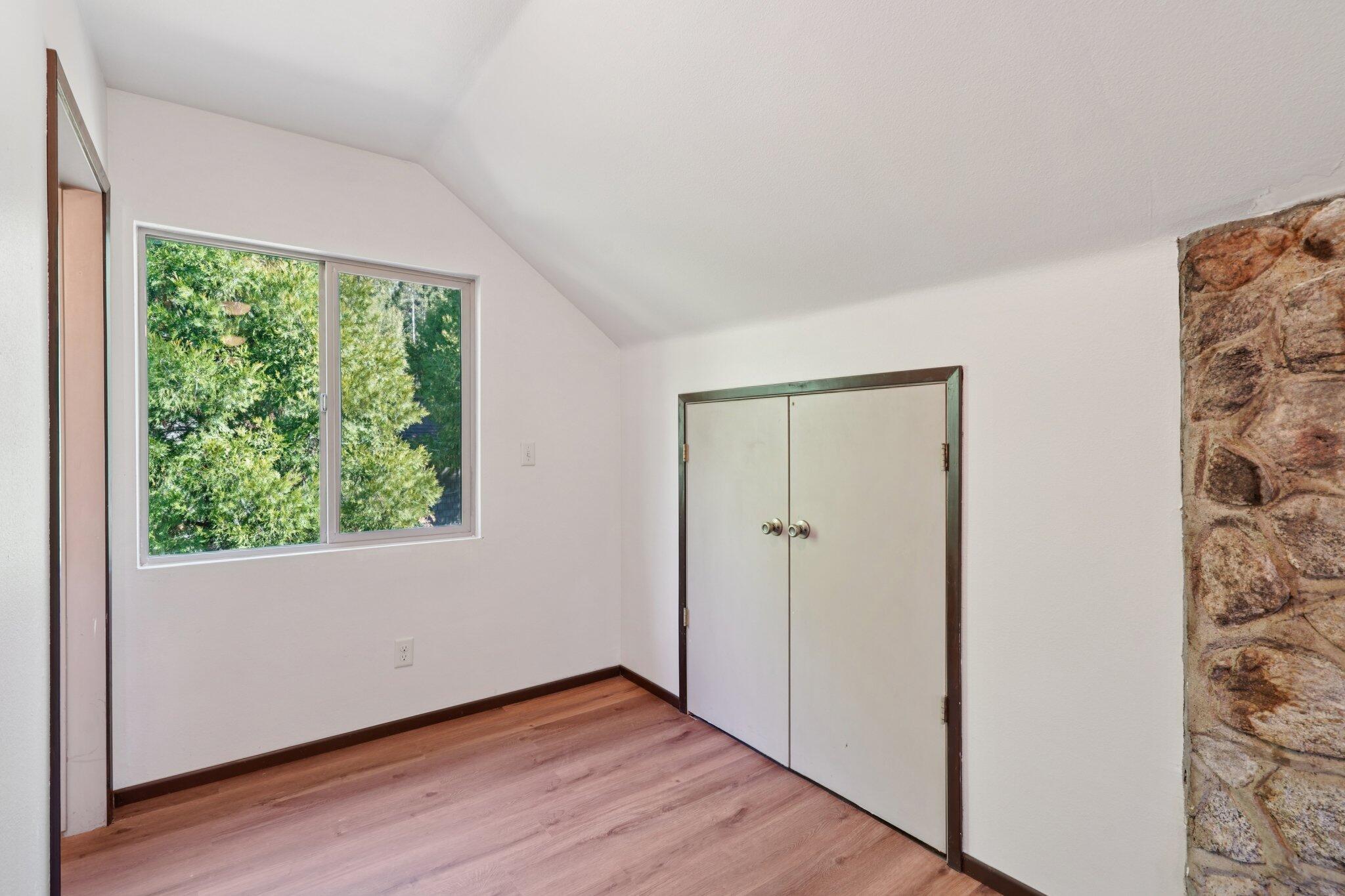 25140 Lodge Road Idyllwild, CA 92549 - Photo 23 of 35 an empty room with wooden floor and windows
