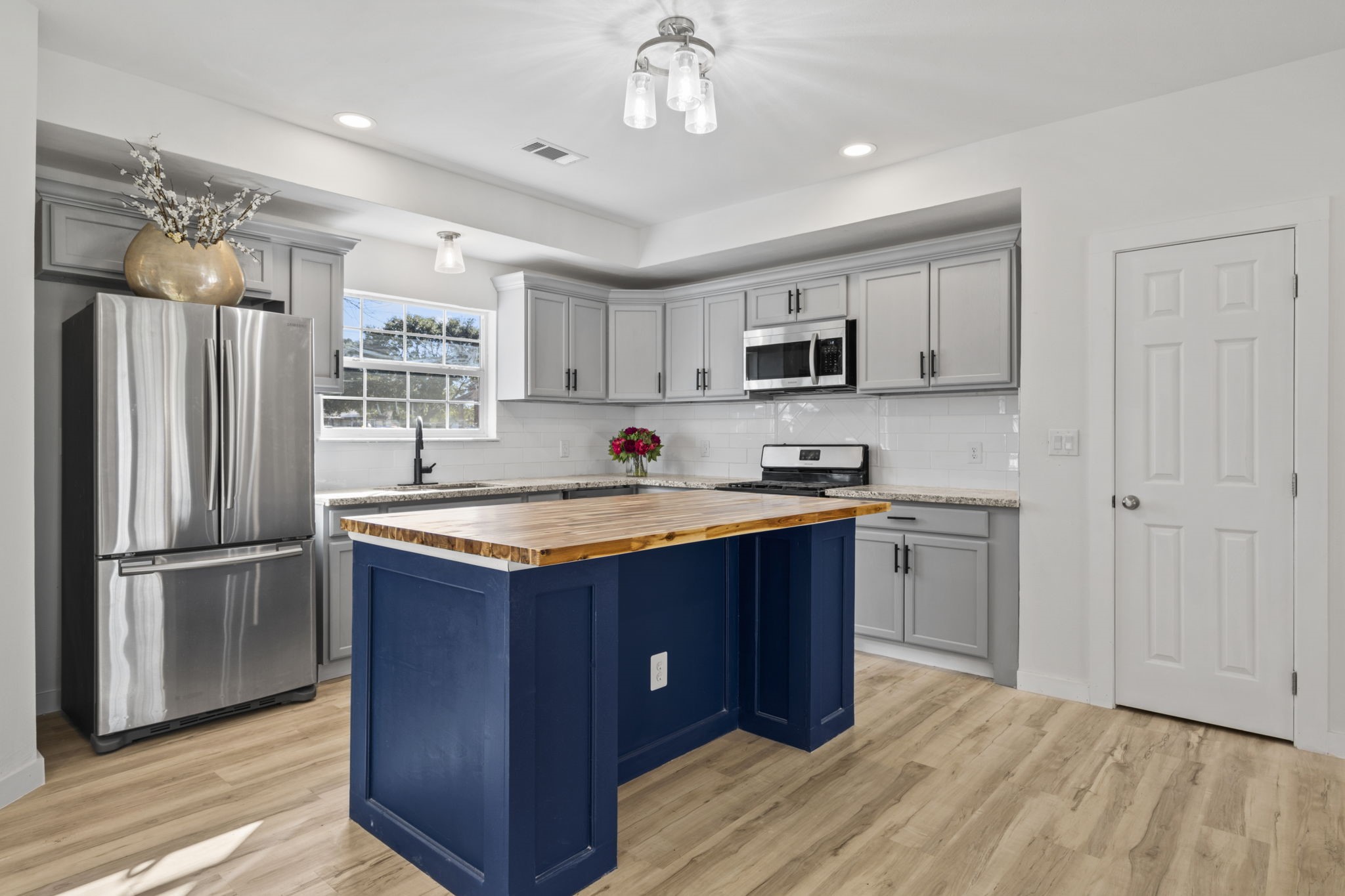 1740 6th Street Hempstead, TX 77445 - Photo 15 of 21 a kitchen with stainless steel appliances granite countertop a refrigerator a sink dishwasher a stove and white countertops with wooden floor