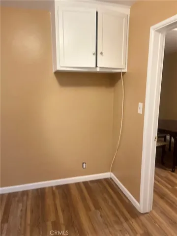 an empty room with wooden floor and a window