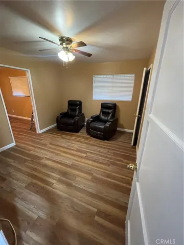 a view of a livingroom with furniture staircase and a ceiling fan