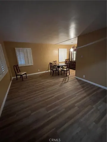 a view of dining room and livingroom with furniture wooden floor a rug and a painting