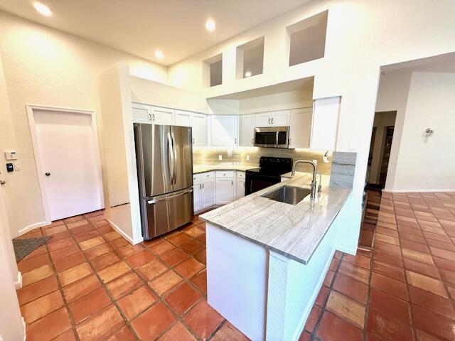 2409 Northwest 66th Drive Boca Raton, FL 33496 - Photo 3 of 15 a kitchen with a sink a refrigerator a stove a microwave and island