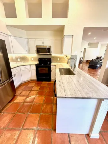 a kitchen with stainless steel appliances kitchen island granite countertop a sink and cabinets