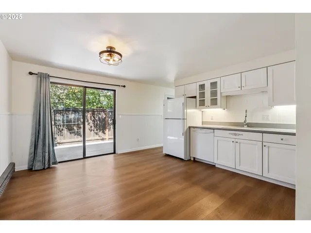 a kitchen with granite countertop a stove a sink and a refrigerator