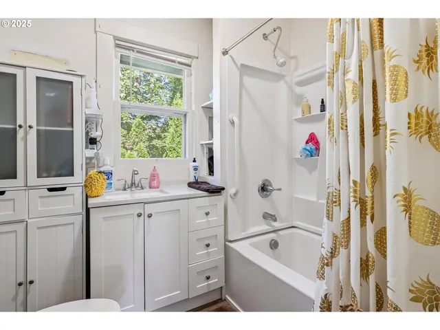 a bathroom with a tub a sink and a window
