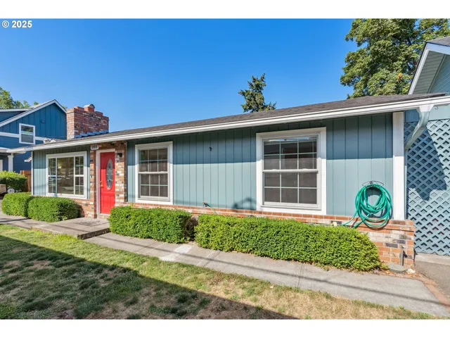 a front view of a house with a yard and potted plants