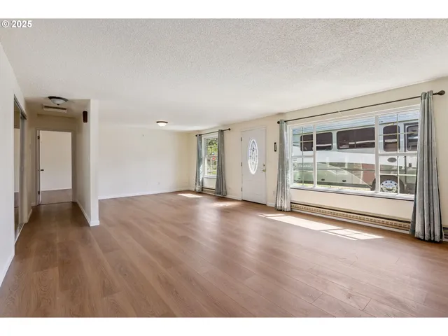 a view of empty room with wooden floor and fireplace