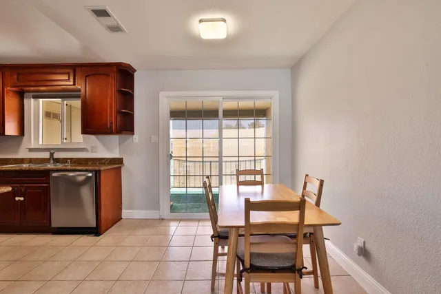 a kitchen with a stove a sink a dining table and chairs