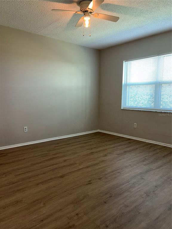 26485 Rampart Boulevard, Unit D1 Punta Gorda, FL 33983 - Photo 11 of 29 an empty room with wooden floor and windows