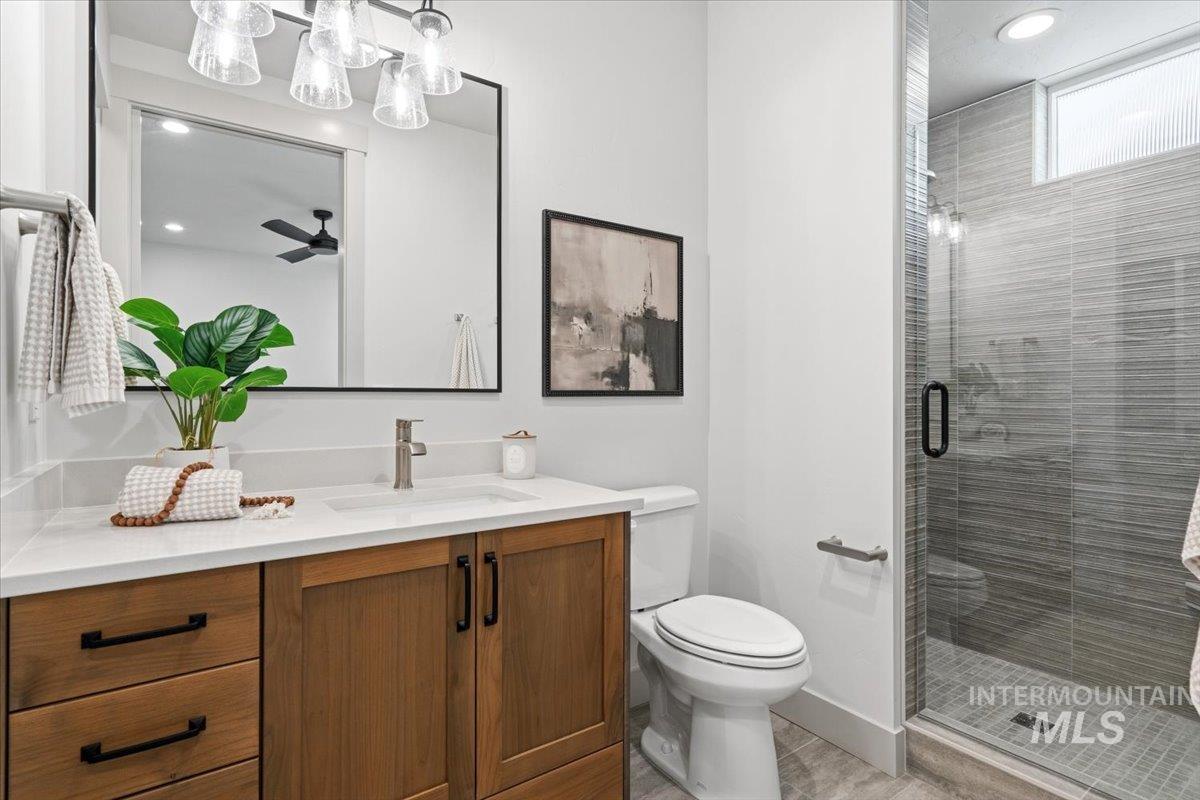 6762 South Messner Way Meridian, ID 83642 - Photo 27 of 35 Modern bathroom featuring a wood-finish vanity with a white countertop and rectangular sink