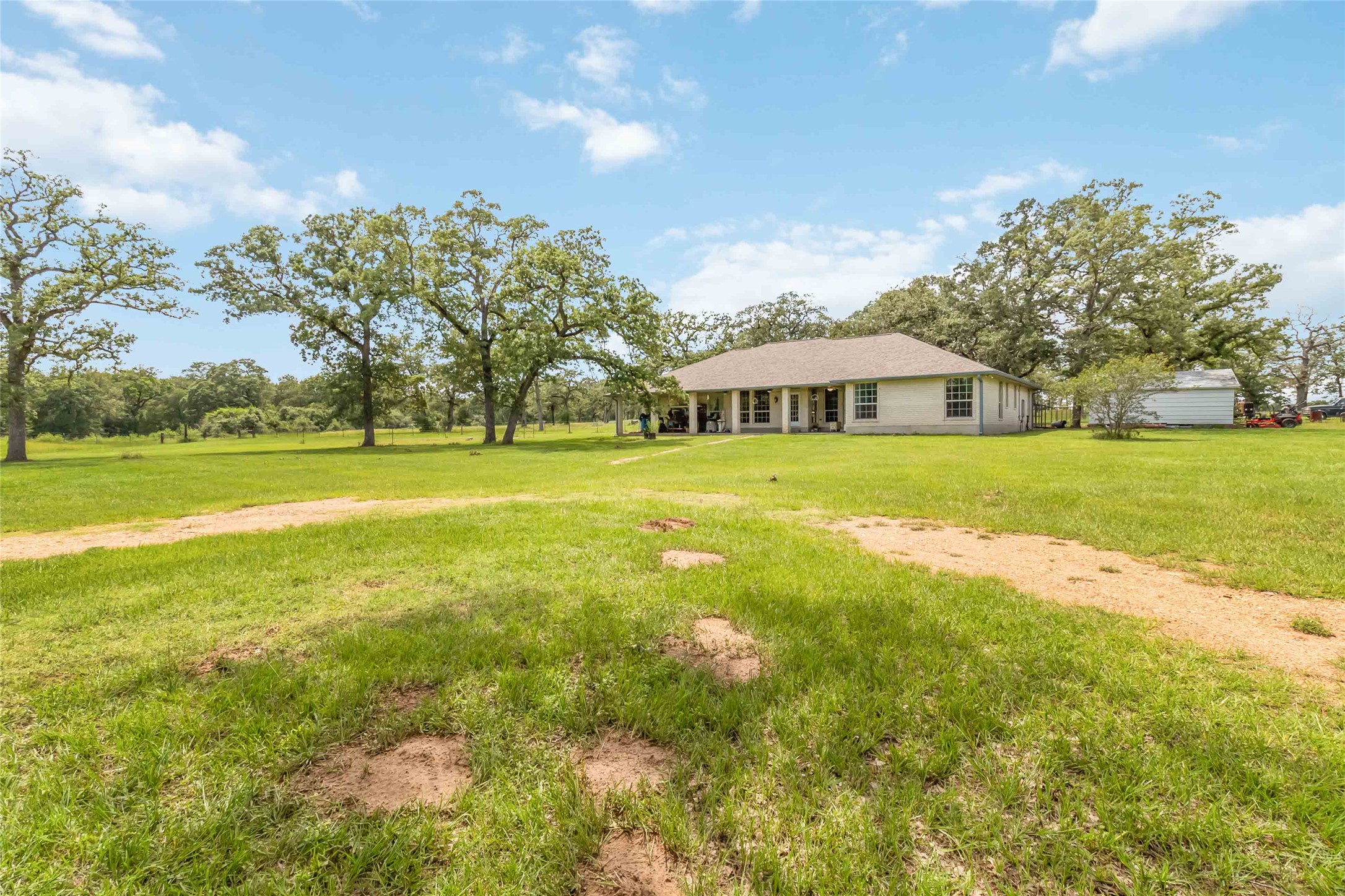 1208 Jeddo Road Rosanky, TX 78953 - Photo 2 of 40 A tranquil rural setting with a cozy home nestled amongst mature trees and green expanses.