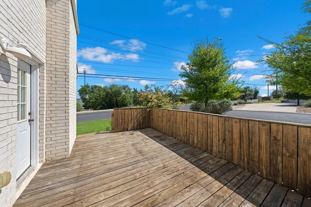 a view of balcony with wooden floor and fence
