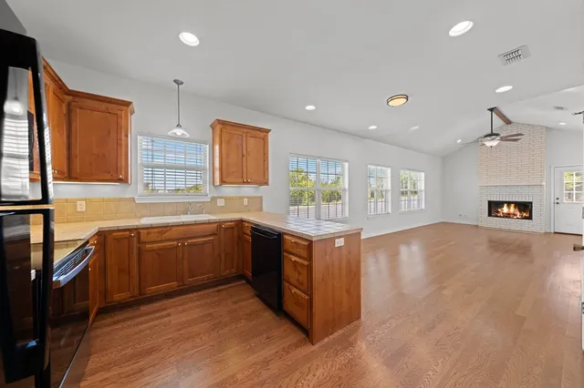 a large kitchen with stainless steel appliances granite countertop a sink stove and wooden floor