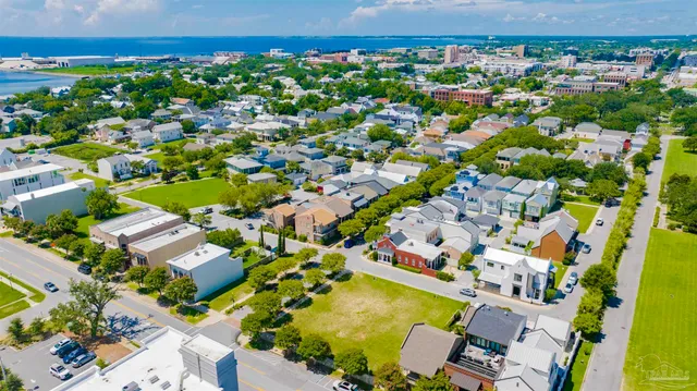an aerial view of residential houses with outdoor space and street view