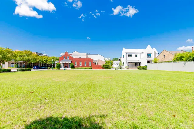an aerial view of a city with lots of residential buildings ocean and mountain view in back