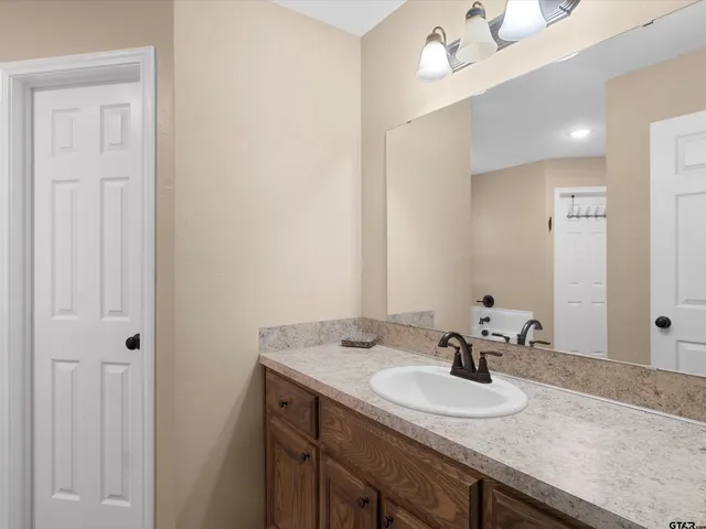 a bathroom with a granite countertop sink and a mirror