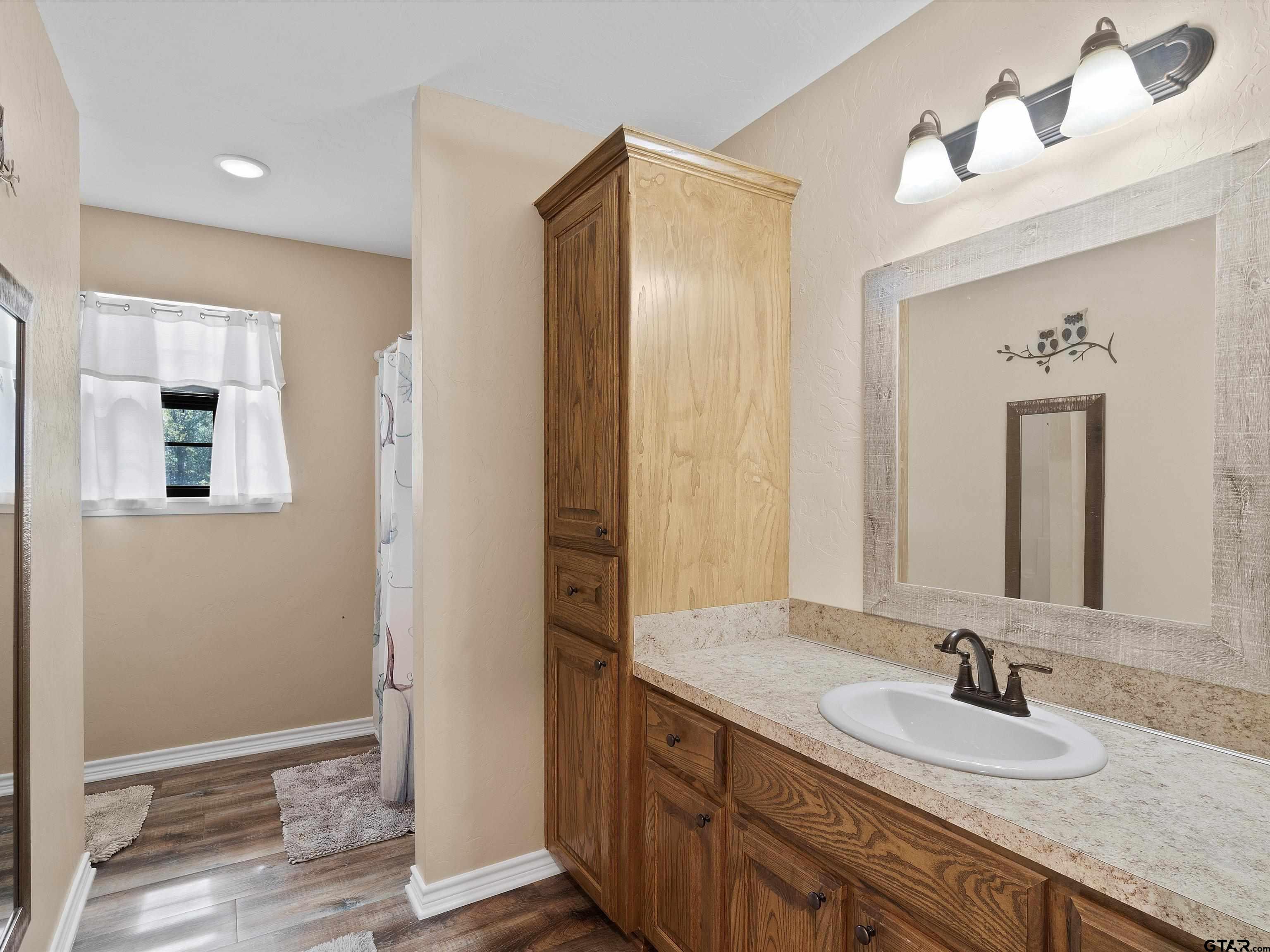 1832 FM 2906 Longview, TX 75603 - Photo 20 of 42 a bathroom with a granite countertop sink and a mirror