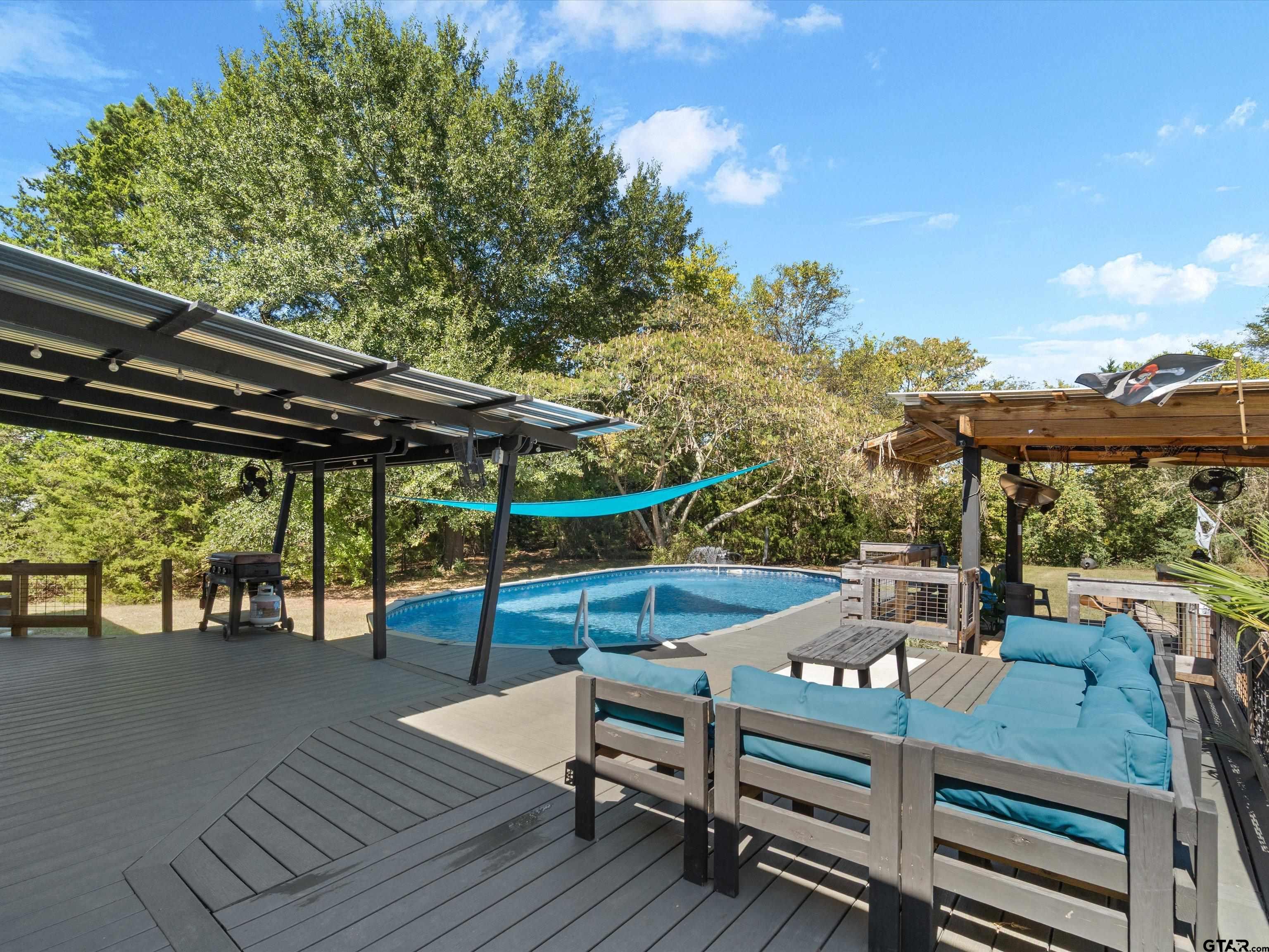 1832 FM 2906 Longview, TX 75603 - Photo 26 of 42 a view of deck with table and chairs a barbeque with wooden floor and fence