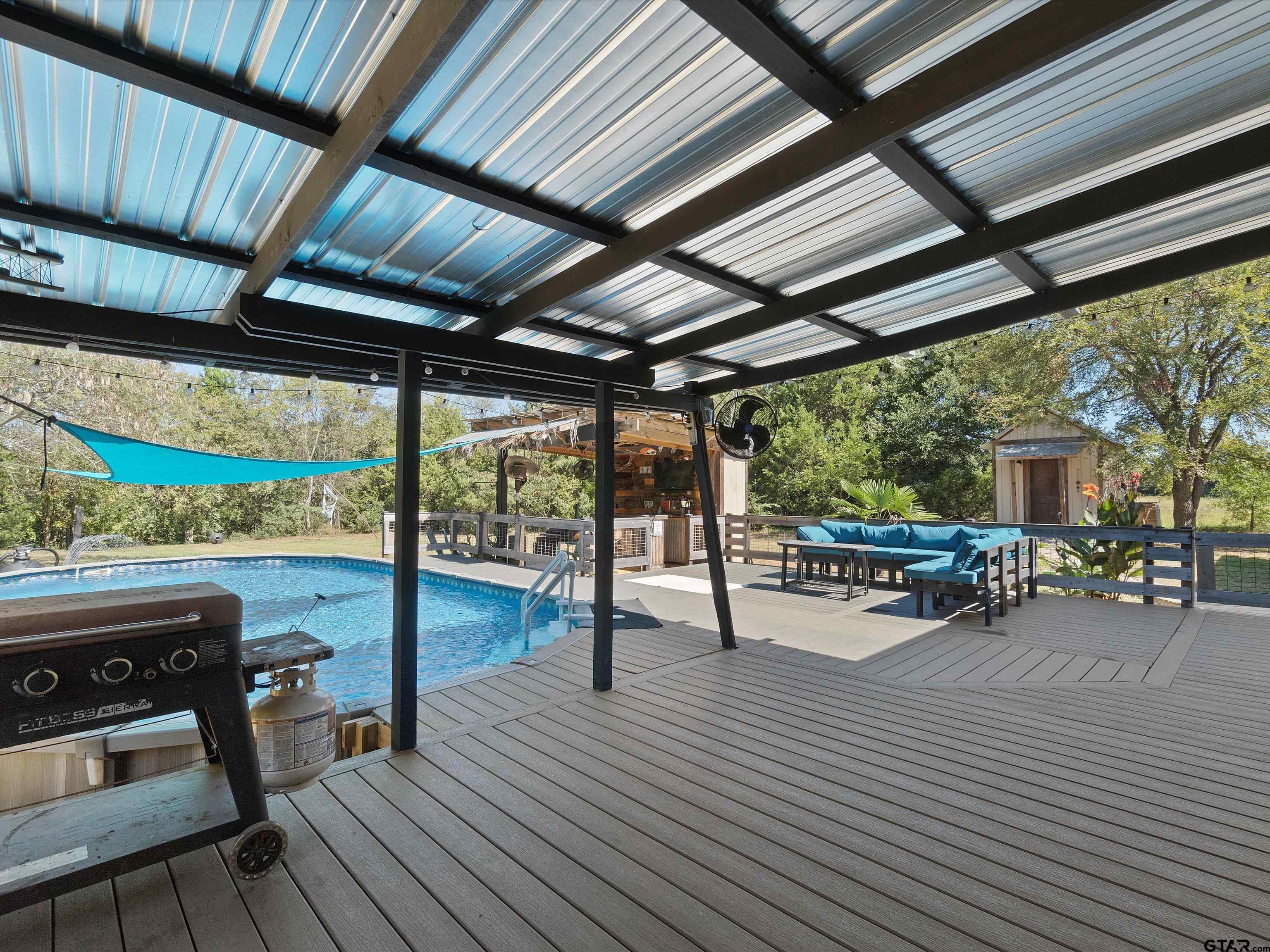 1832 FM 2906 Longview, TX 75603 - Photo 27 of 42 a view of a patio with table and chairs a barbeque with wooden floor and roof with a barbeque grill