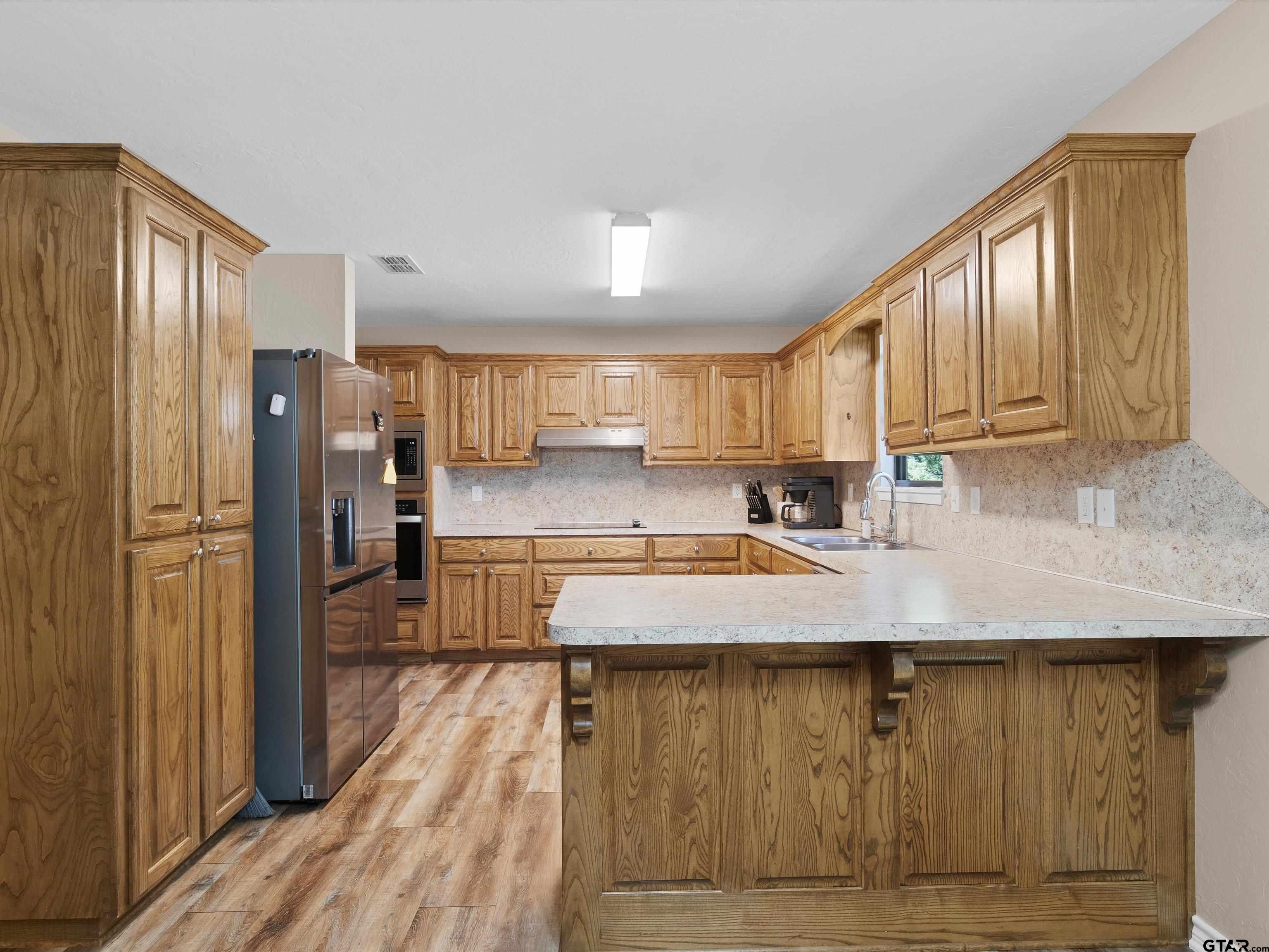 1832 FM 2906 Longview, TX 75603 - Photo 10 of 42 a kitchen with stainless steel appliances granite countertop a refrigerator a sink and wooden cabinets