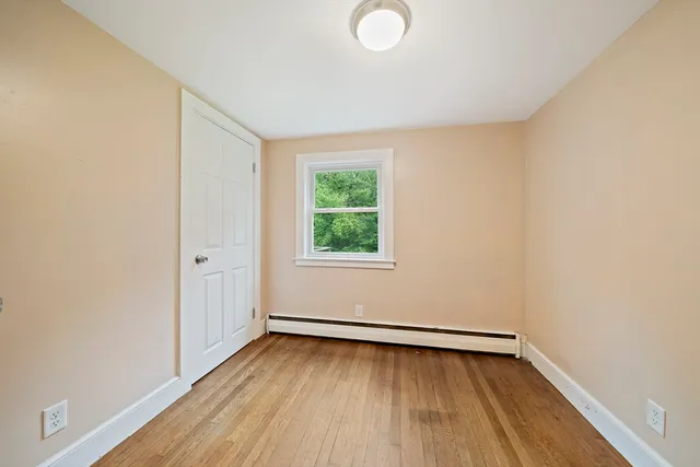 a view of a room with wooden floor and window