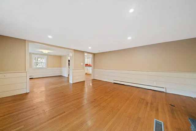 a view of empty room with wooden floor