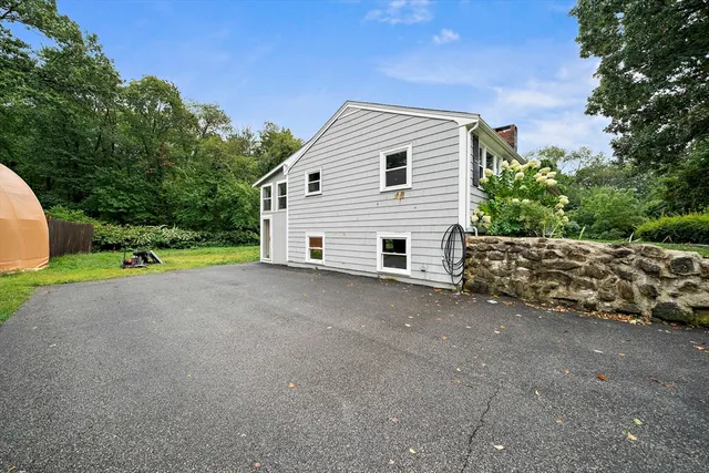 a view of a house with backyard and trees