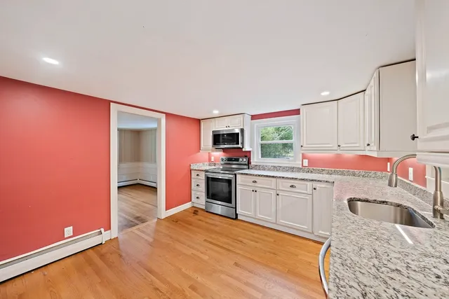 a kitchen with granite countertop a stove top oven sink and cabinets