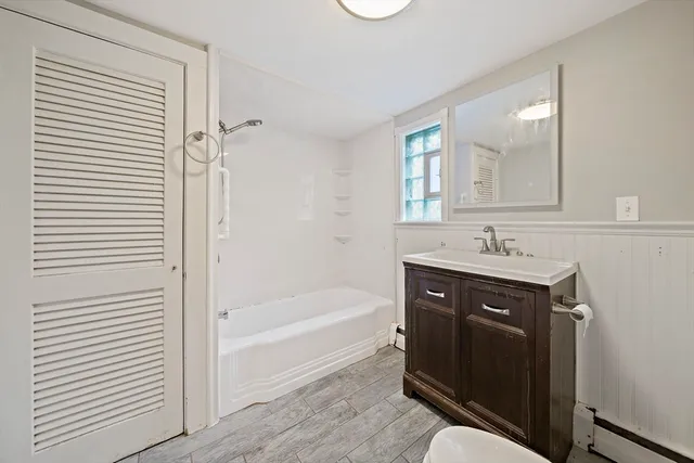 a bathroom with a tub sink and mirror