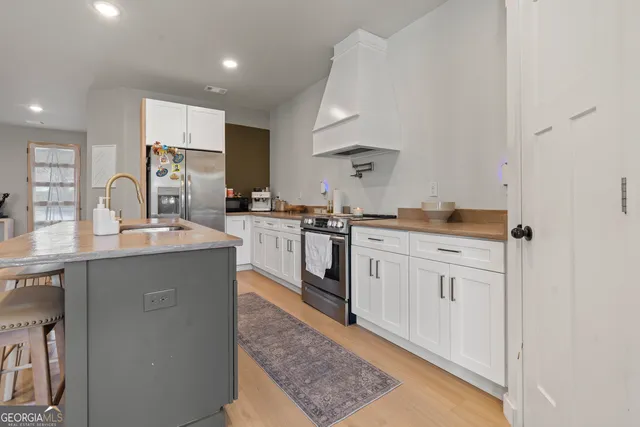 a kitchen with white cabinets and sink