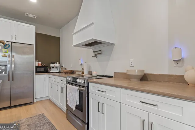 a kitchen with stainless steel appliances granite countertop a sink a stove and refrigerator