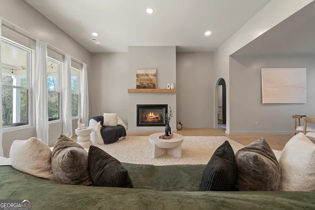 a living room with furniture fireplace and a large window
