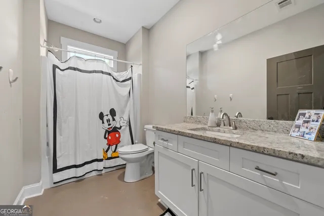 a bathroom with a granite countertop sink toilet and shower