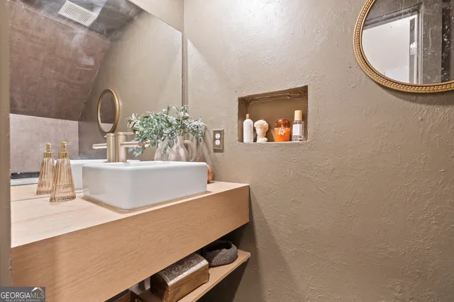 a view of a room with a sink and mirror