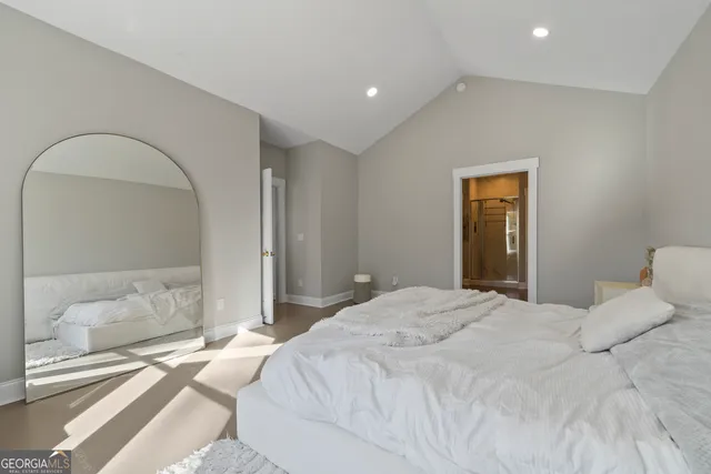 a spacious bedroom with a bed and a mirror