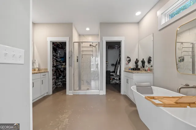 a bathroom with a tub sink shower and mirror