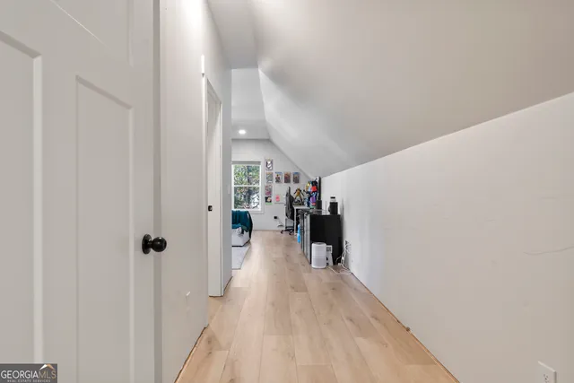 a view of a hallway with furniture and wooden floor